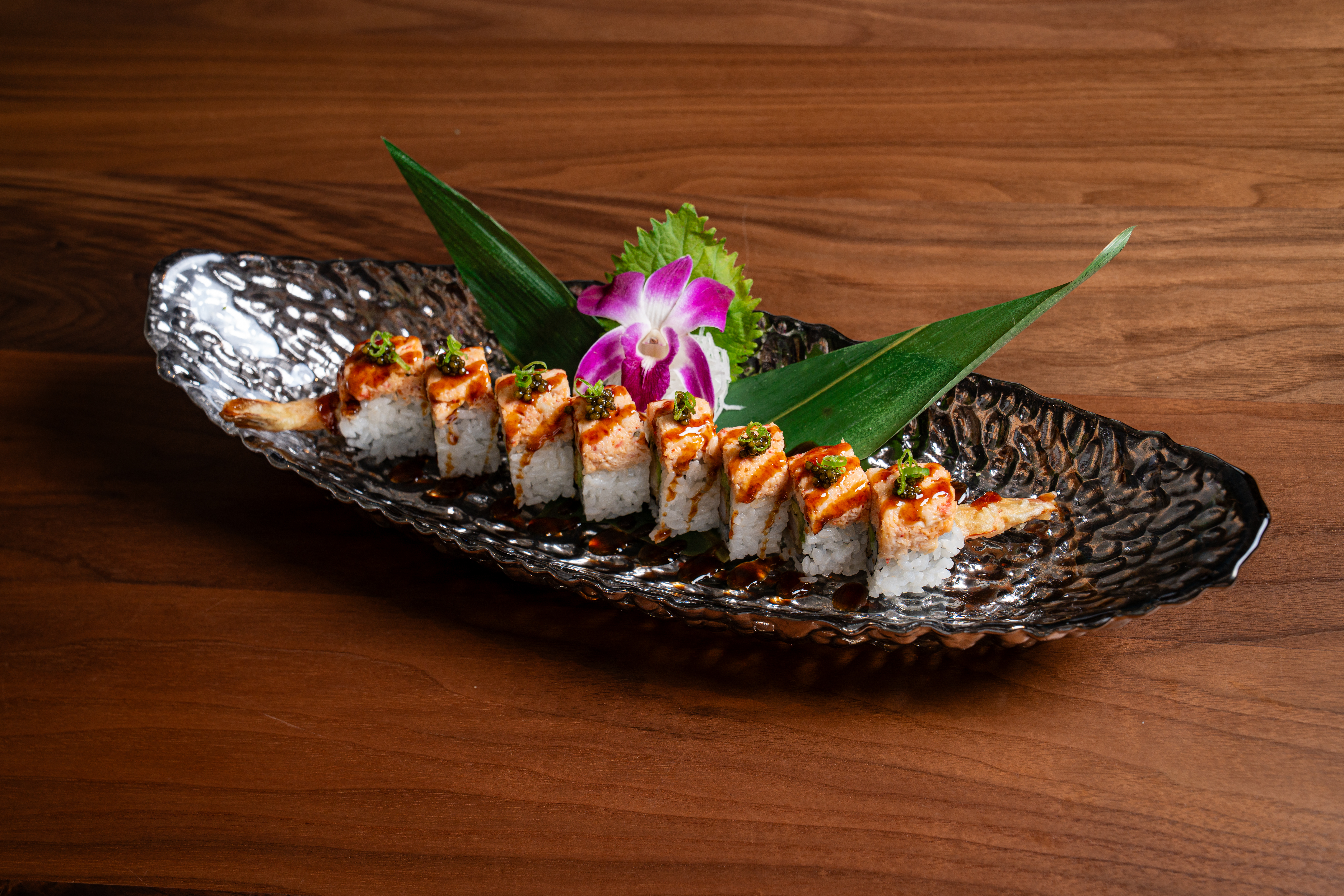 a plate of sushi on a wood table