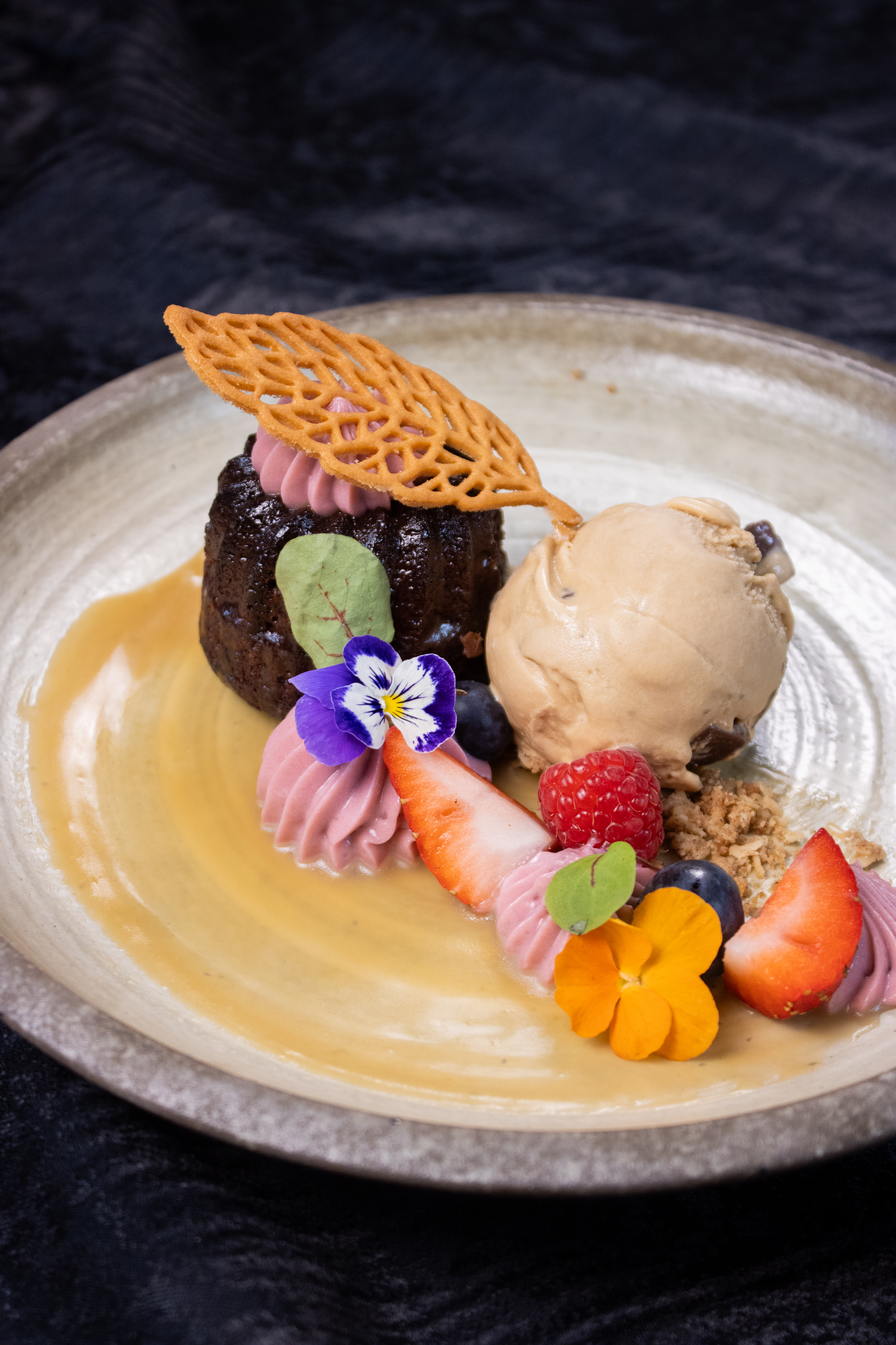 a plate of dessert with ice cream and fruit