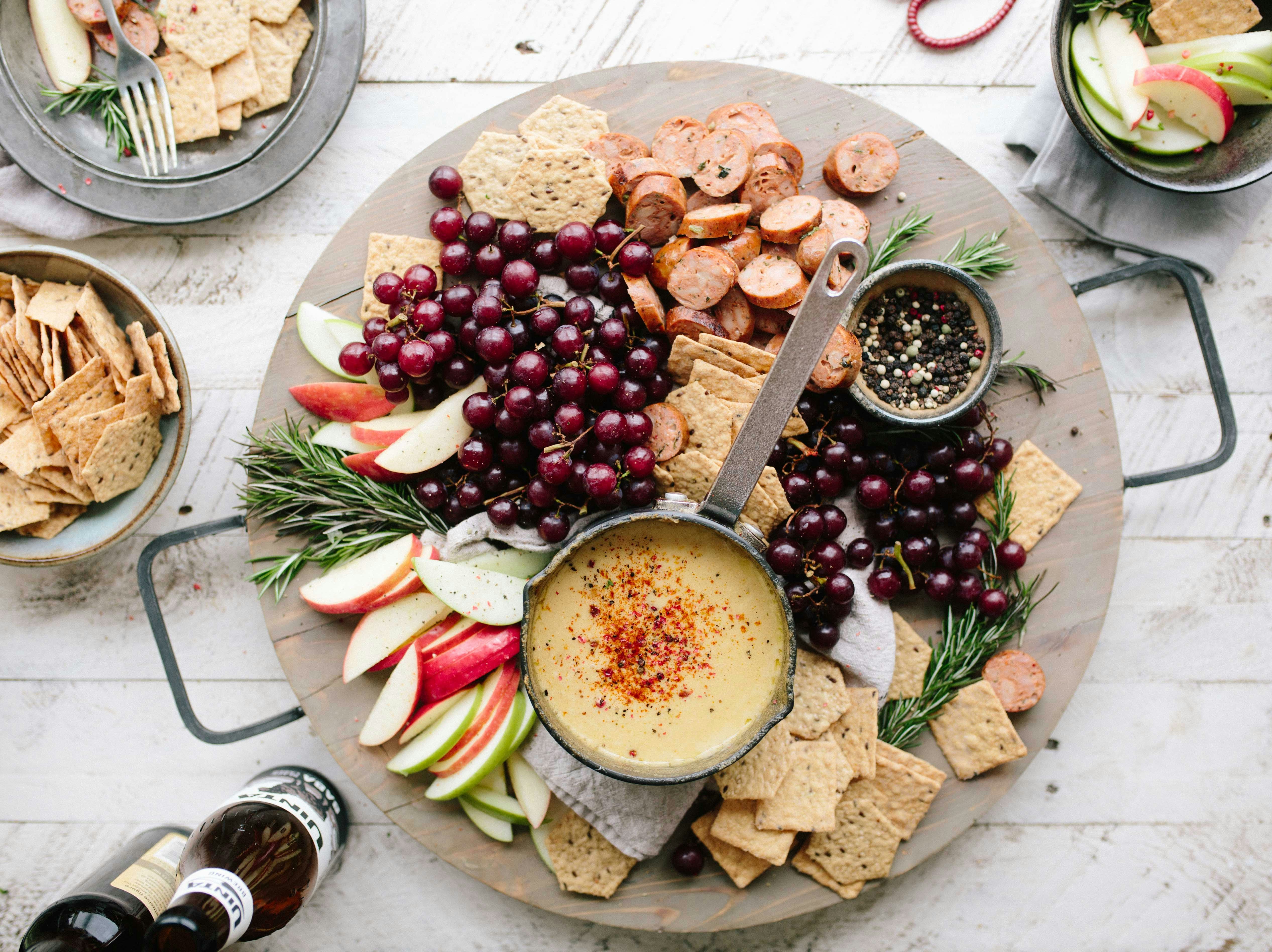 a platter of food with a dip and fruit