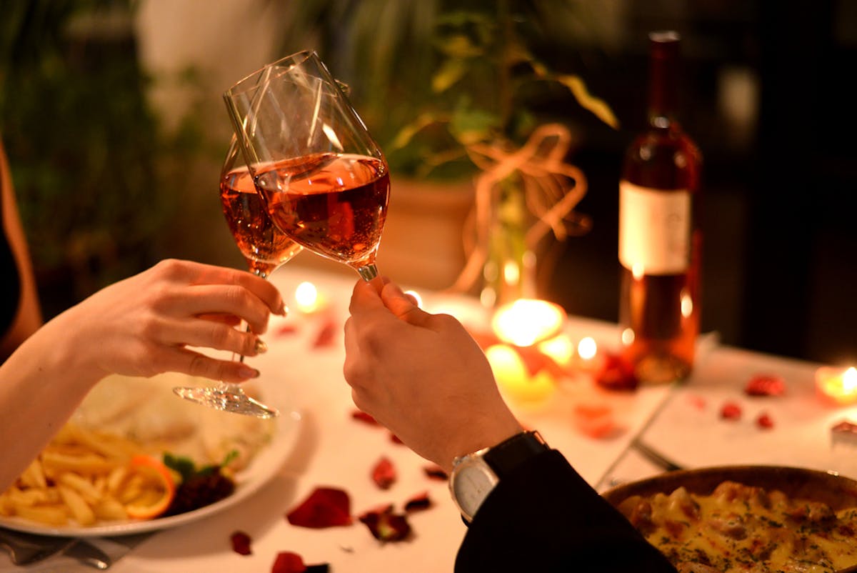 a person sitting at a table with wine glasses