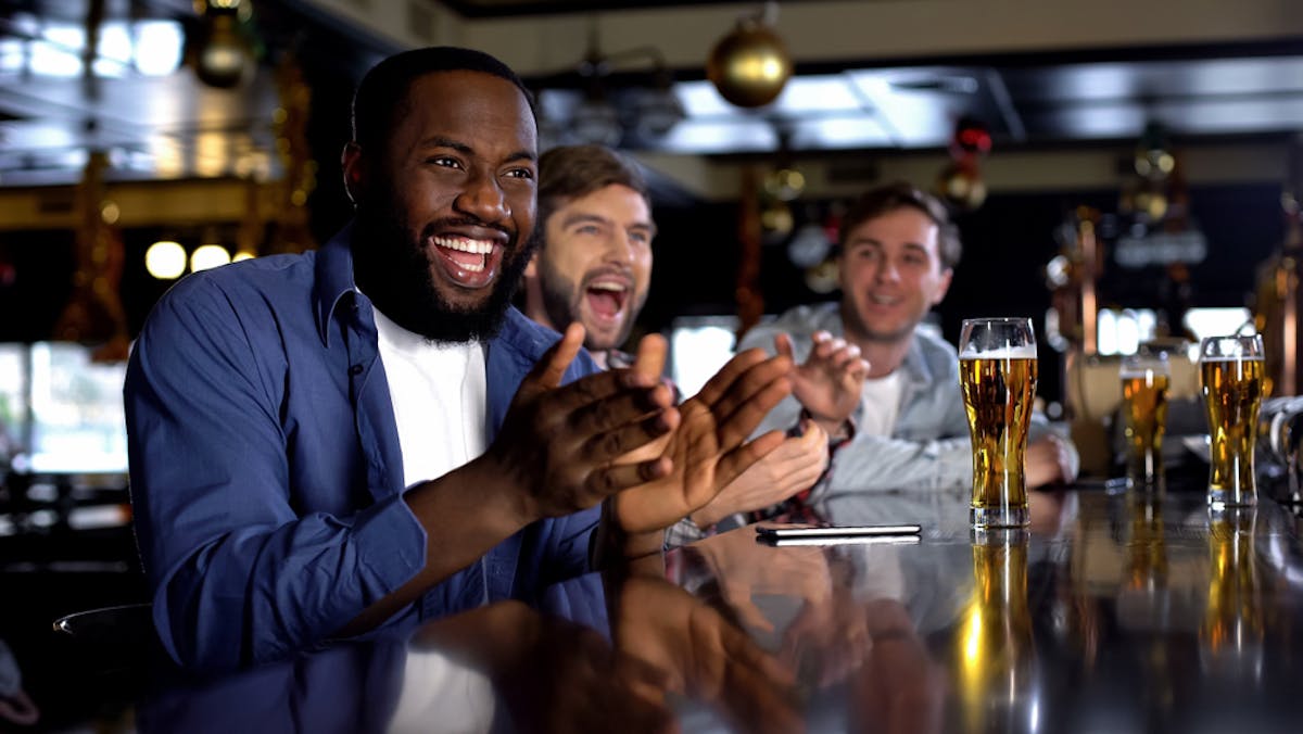 friends watching March Madness with beer at a bar