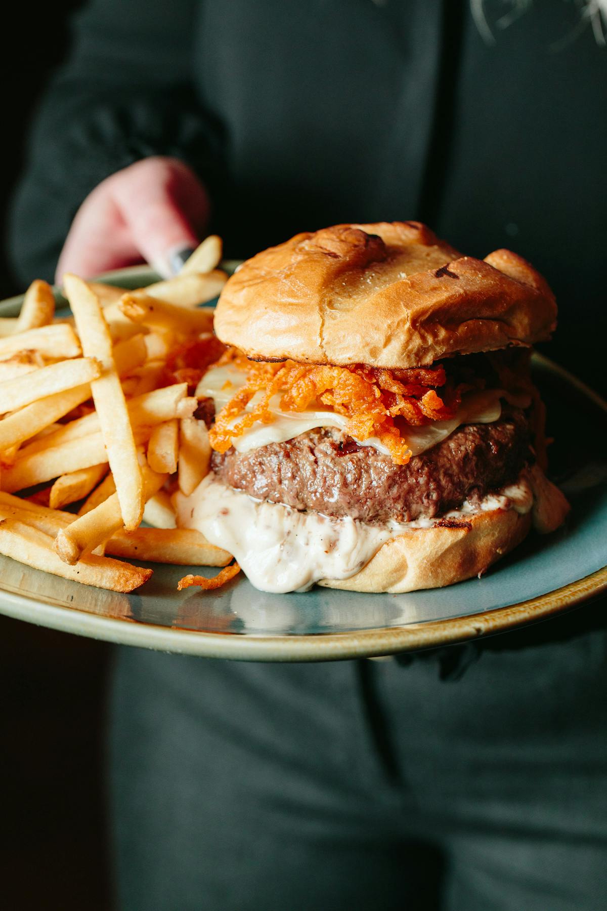 a close up of a burger and fries on a plate