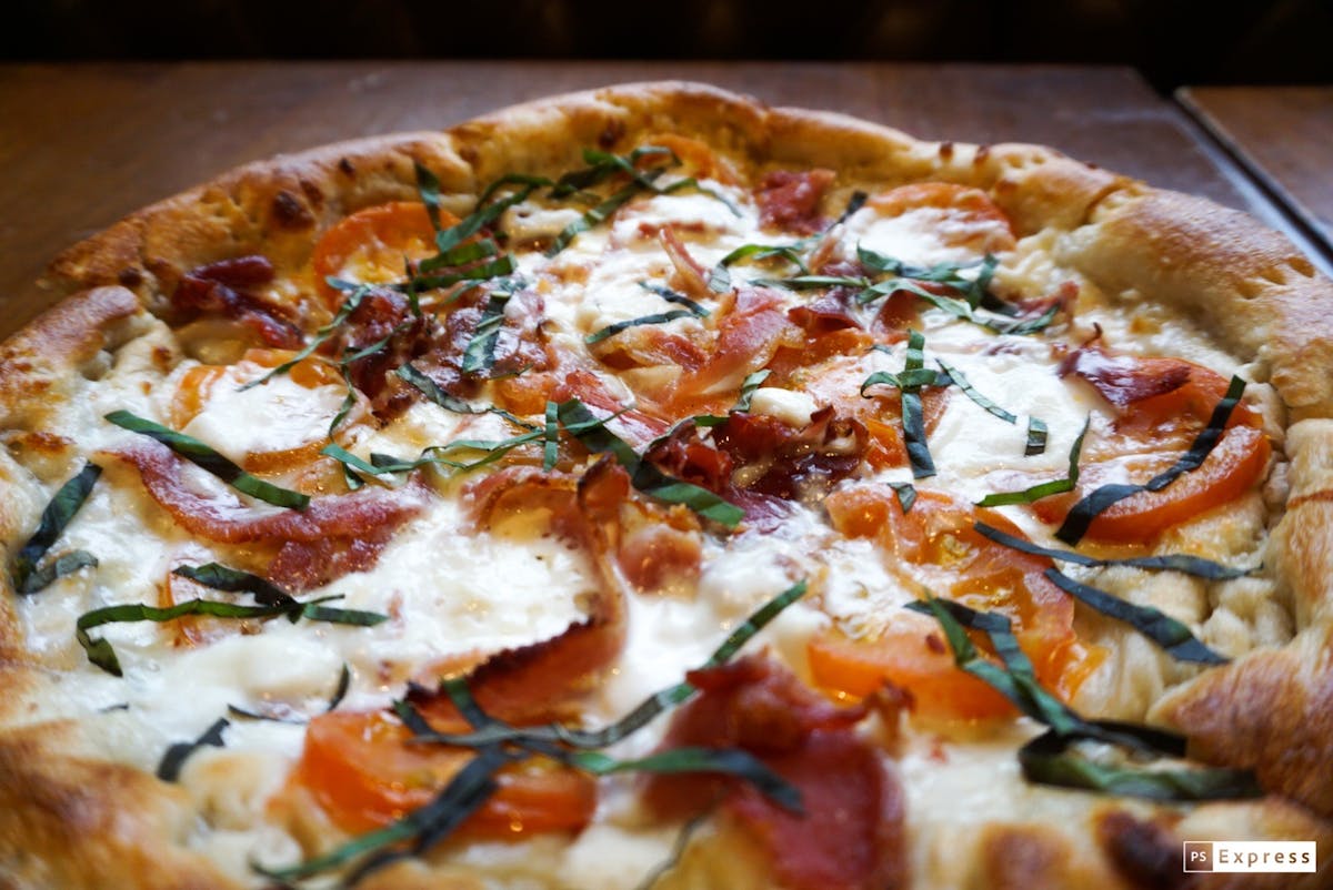 a pizza sitting on top of a wooden cutting board