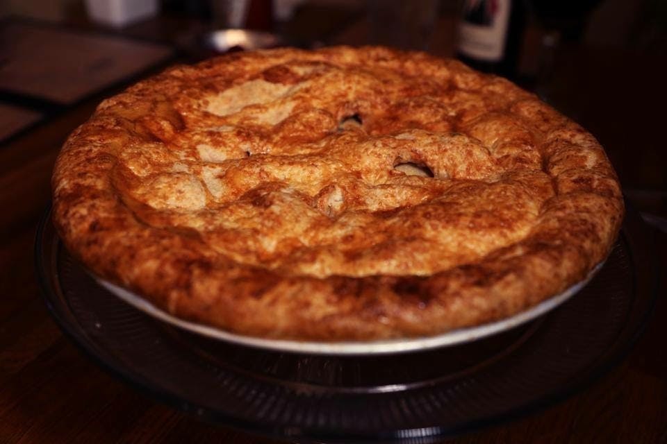 a pizza sitting on top of a pan on a table