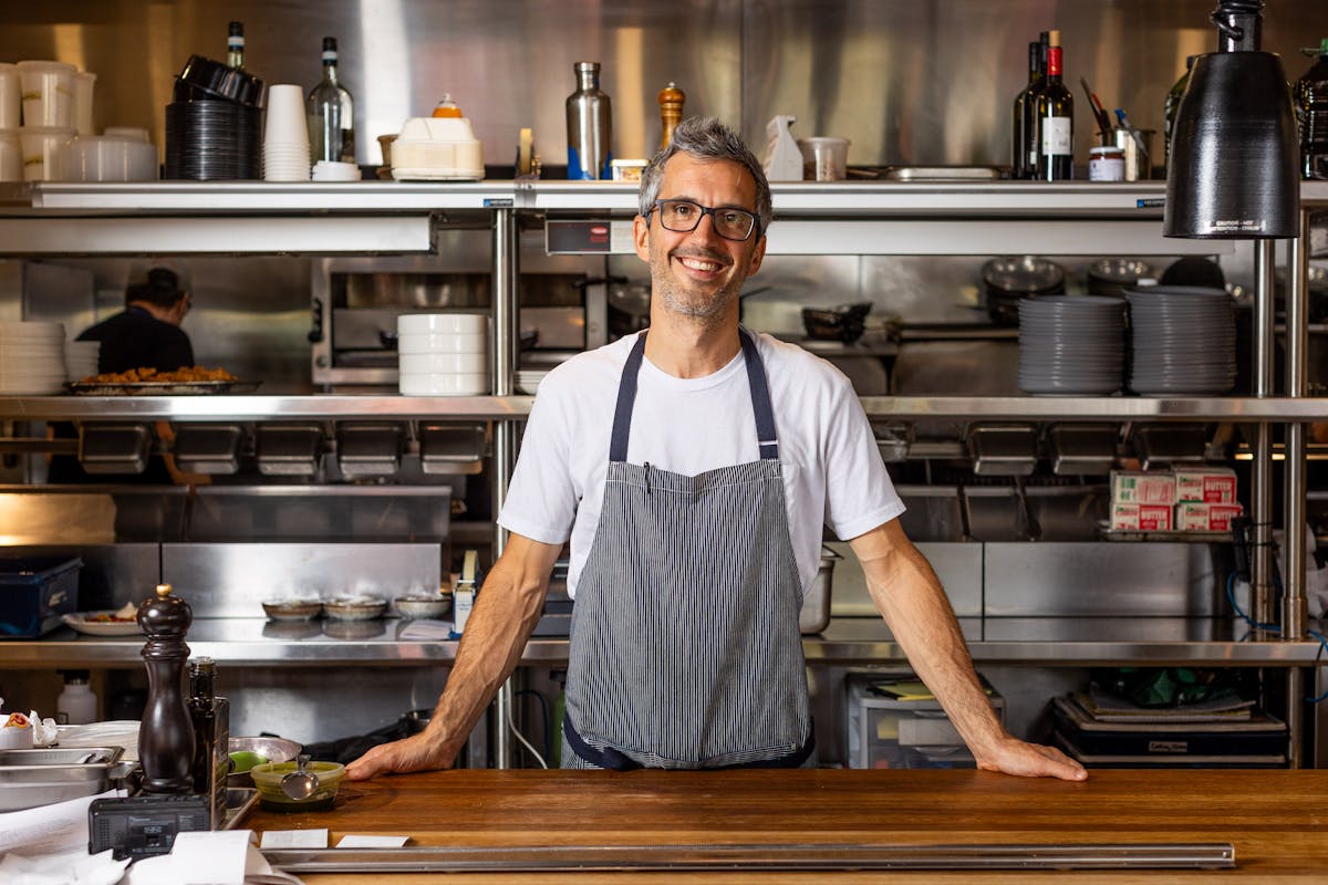 a man standing in a kitchen preparing food