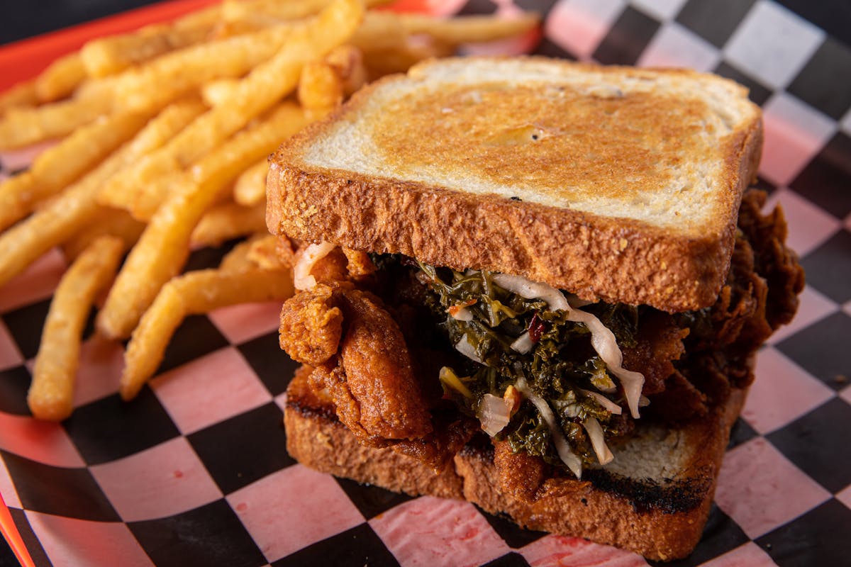 a close up of a sandwich and fries on a plate