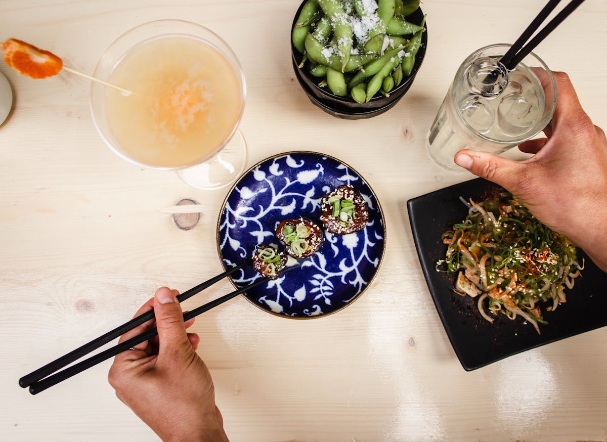 a person holding a plate of food with a knife