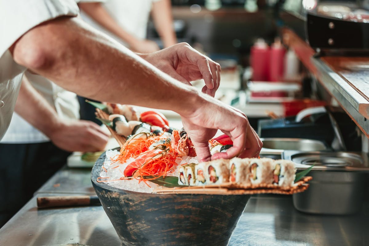 9857393967In Kitchen Sushi Platter Assembly Chef Arm In Shot ?w=1200&fit=crop&auto=compress,format&crop=focalpoint&fp X=0.5&fp Y=0.5