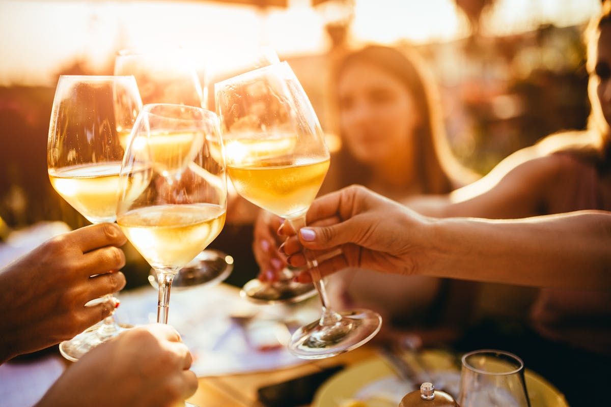 a woman sitting at a table with wine glasses