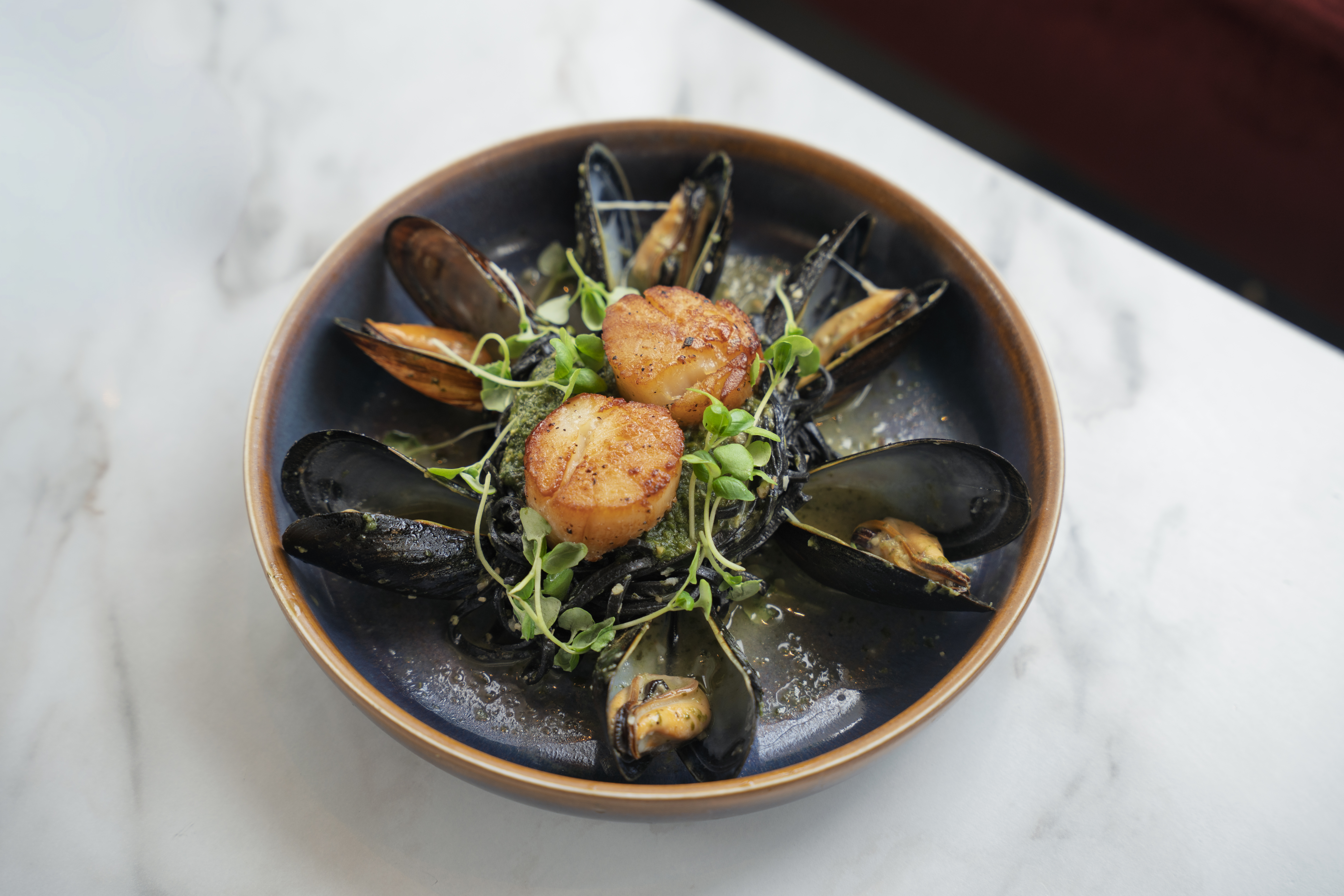 Scallops & Mussels over squid ink linguini with citrus white wine sauce