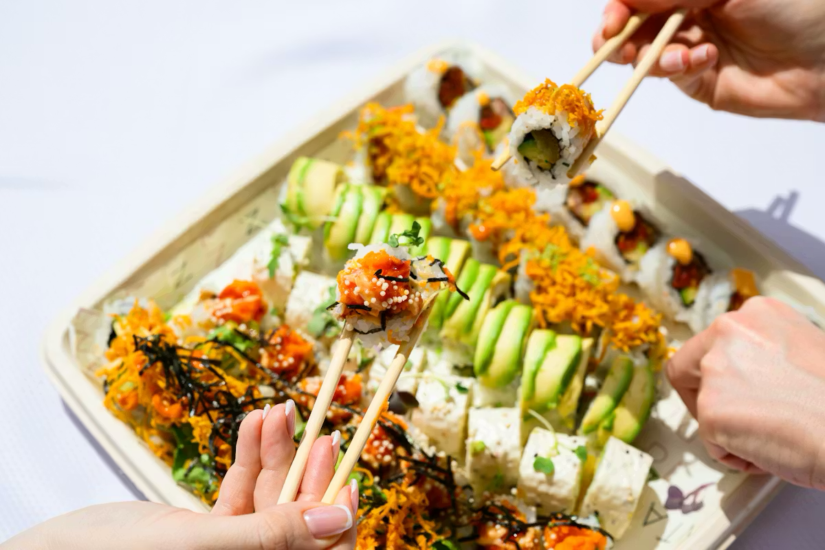 a plate of sushi with chopsticks