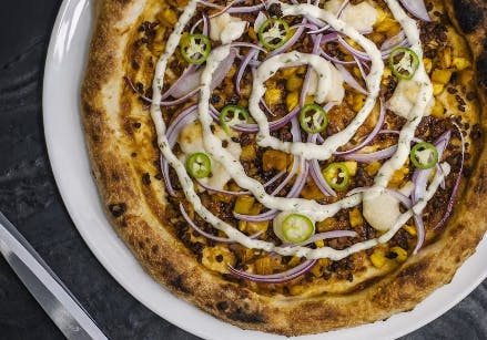 a pizza sitting on top of a plate of food