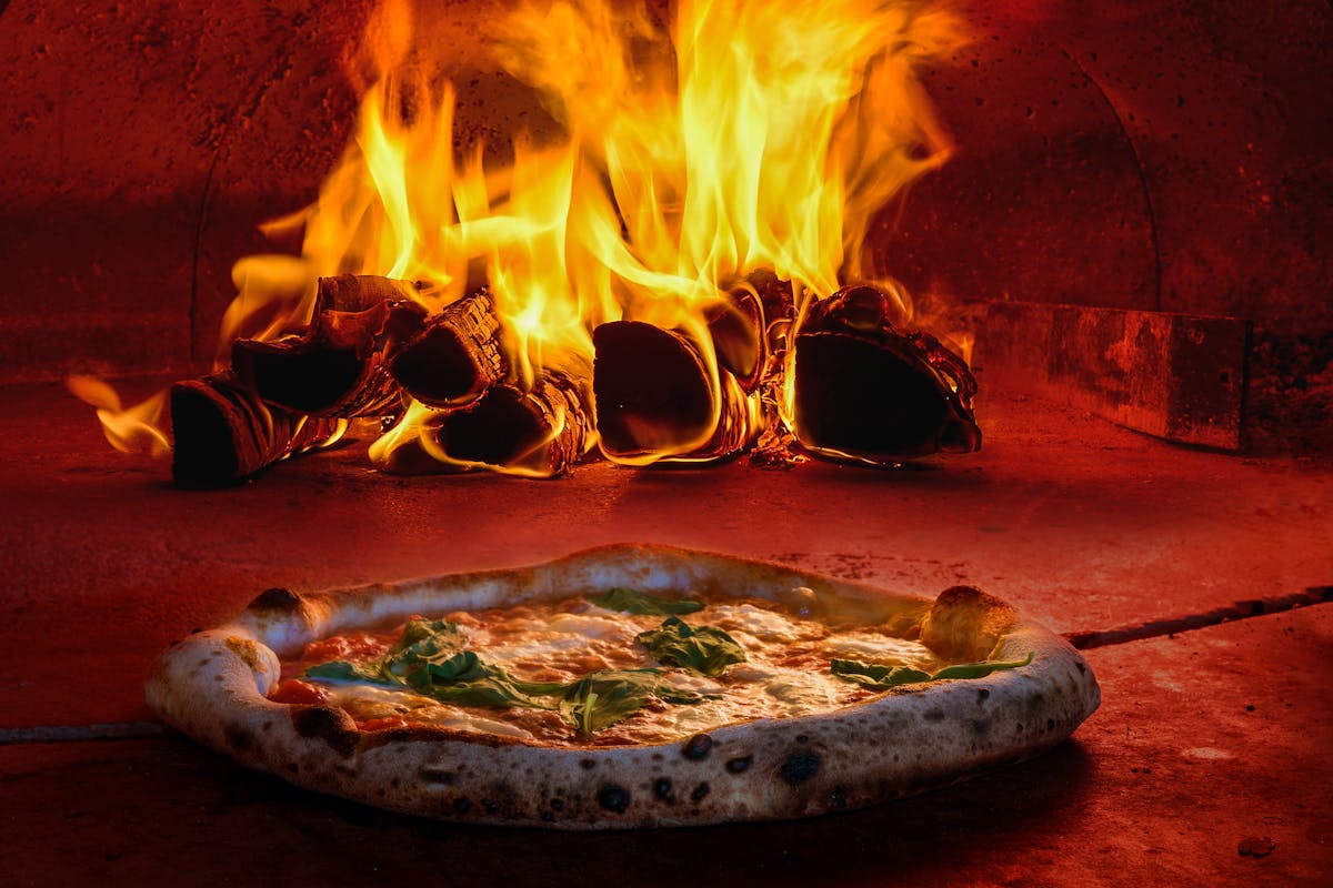 a pizza sitting on top of a fire