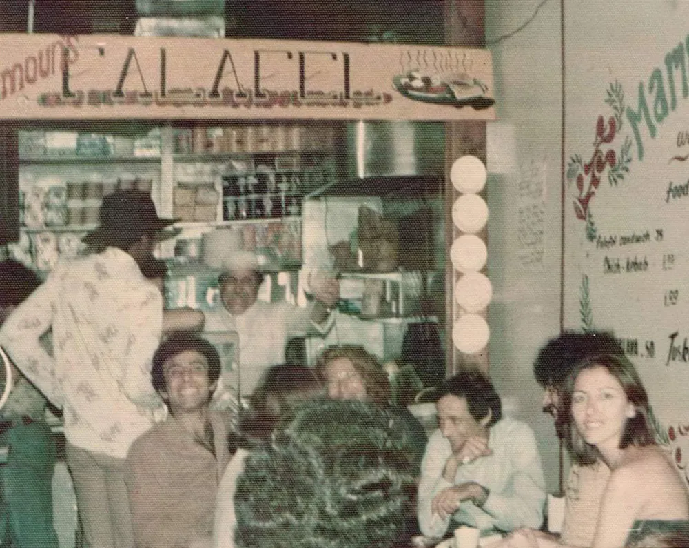Vintage color photo of the original Mamoun's Falafel counter with customers