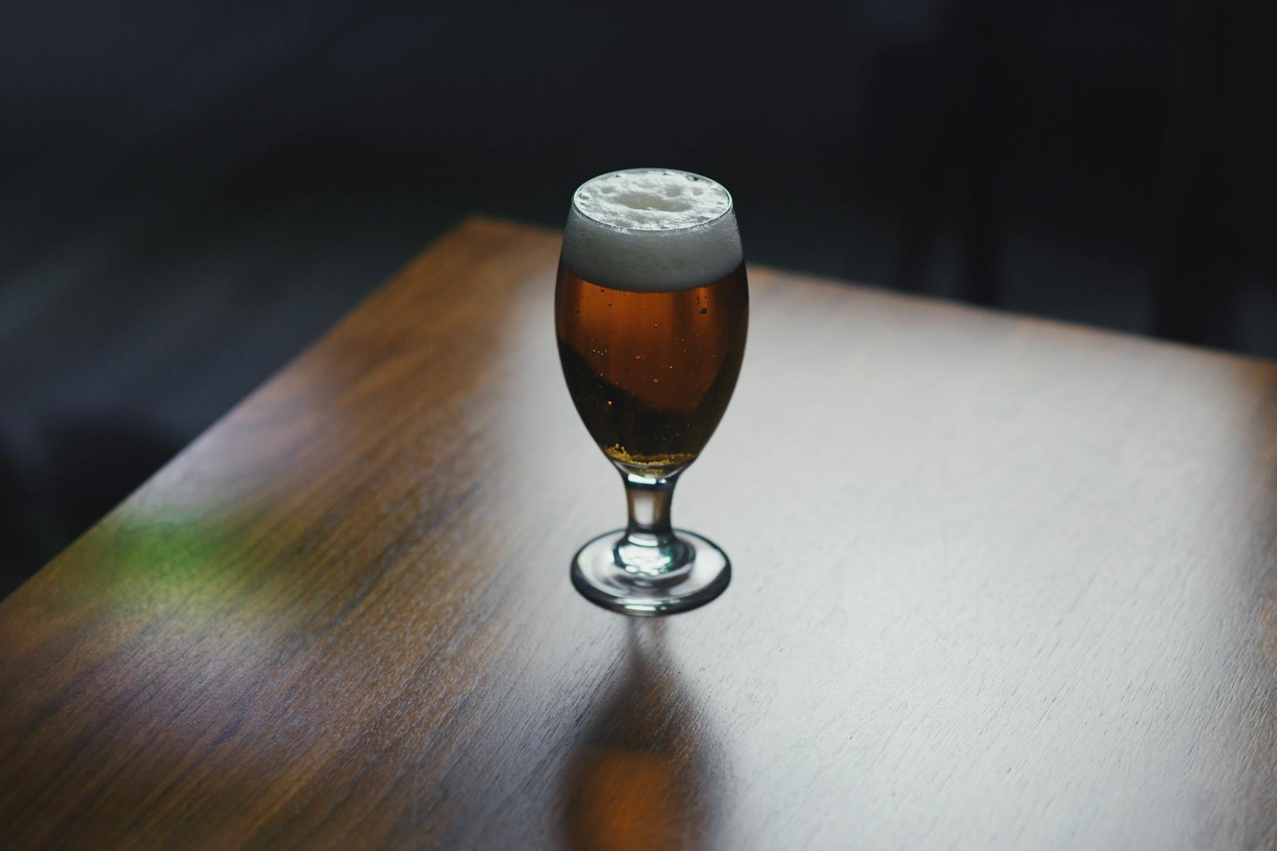 a glass of wine sitting on top of a wooden table
