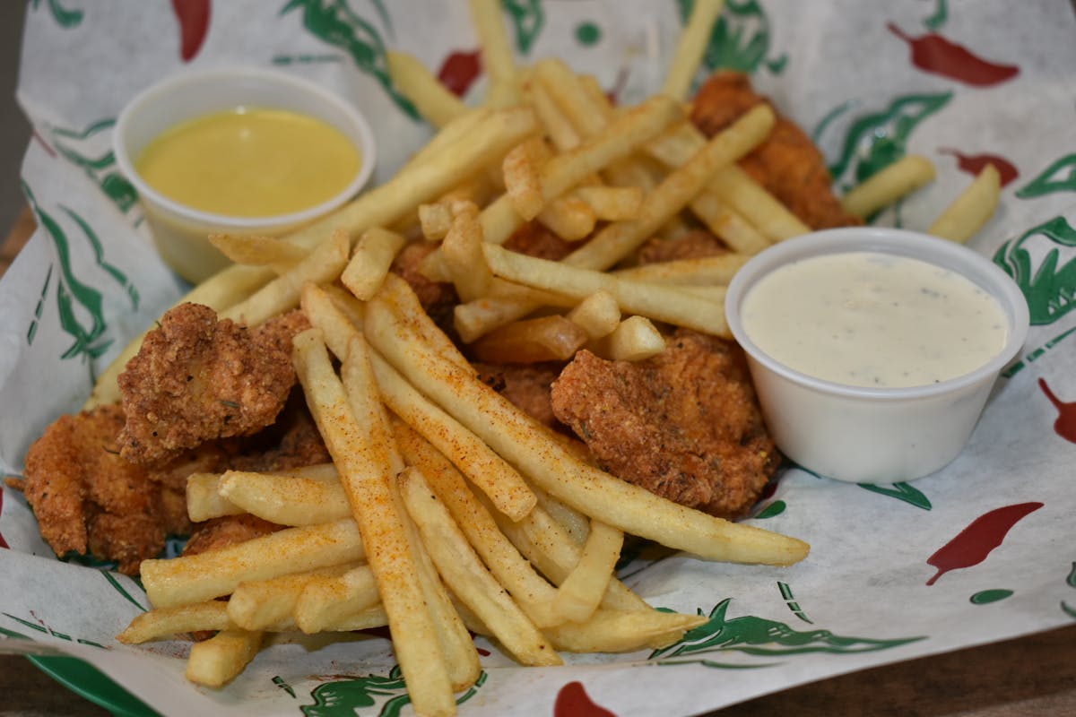 chicken tenders  that is sitting on the side of fries