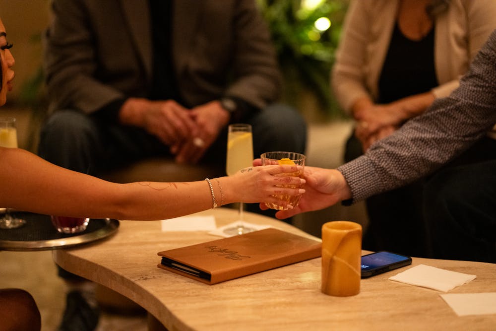 a cocktail server at the durango lounge, Bel-Aire, passing a cocktail to a guest