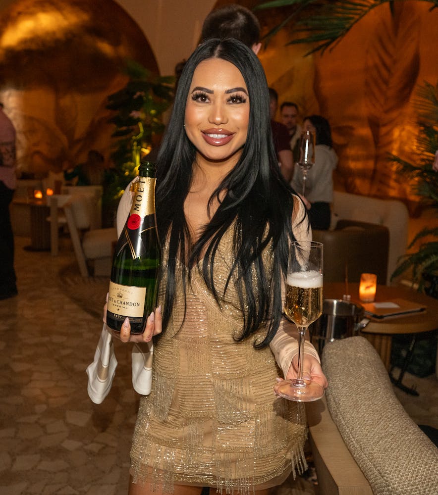 Cocktail server of Bel-Aire Lounge, best local bar, with a bottle of Moet Champagne