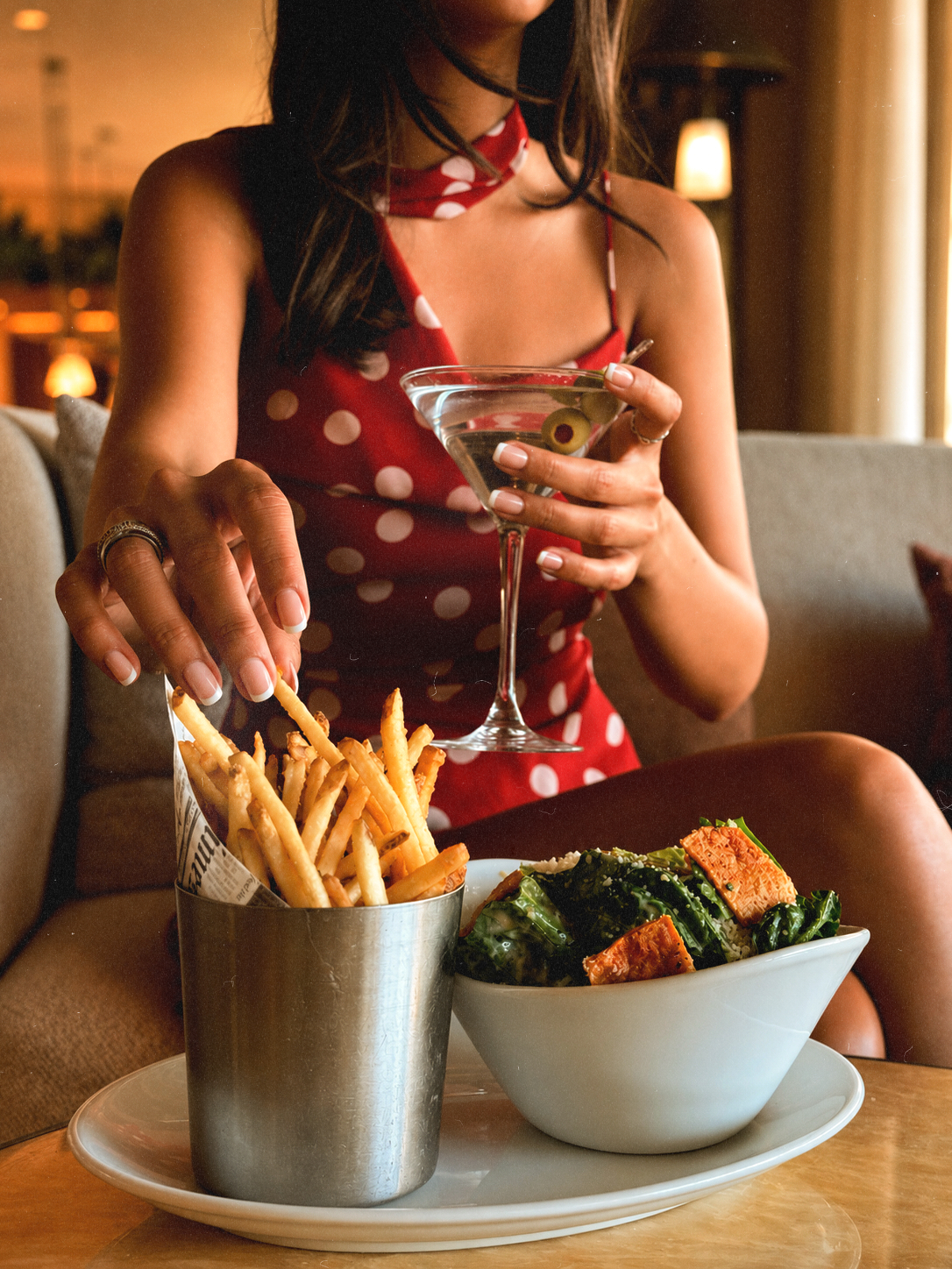 Guest enjoying Tini Girl Dinner with a martini, fries, and Caesar salad at Bel-Aire Lounge, a popular local lounge and Thursday Ladies Night destination in Las Vegas.
