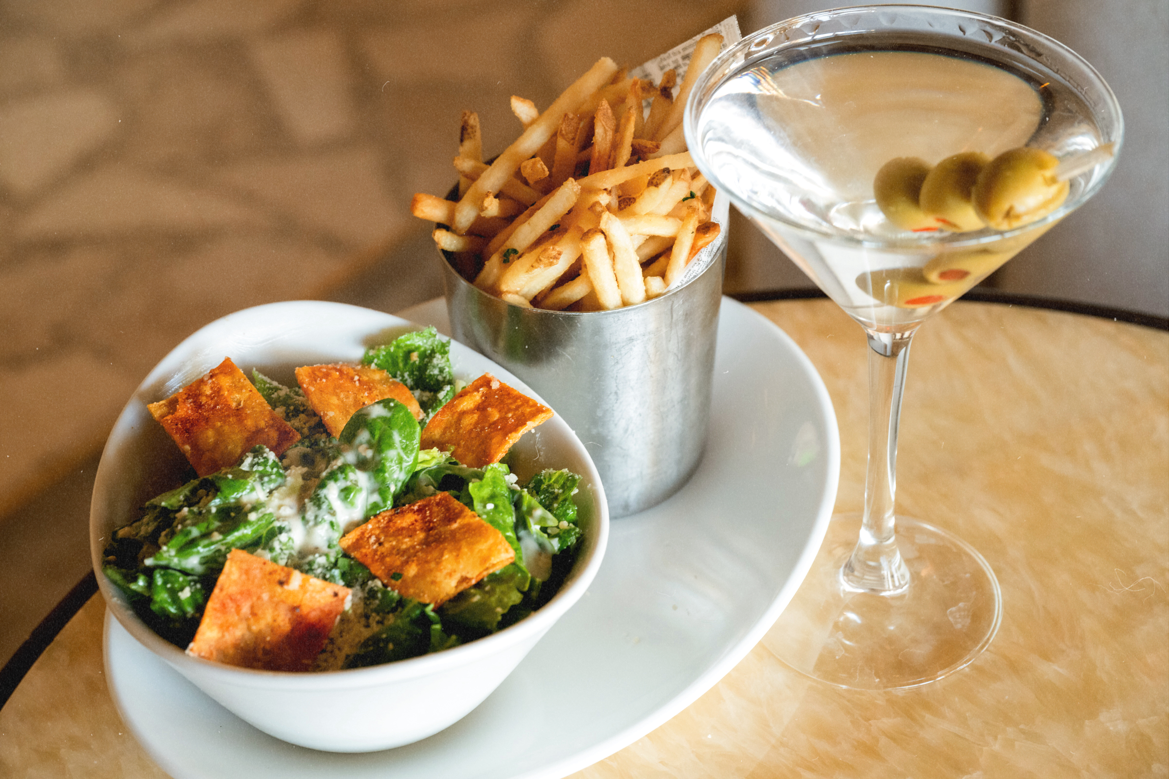 Tini Girl Dinner at Bel-Aire Lounge featuring a martini, crispy fries, and Caesar salad, available every Thursday inside the premier Las Vegas lounge at Durango Casino & Resort.