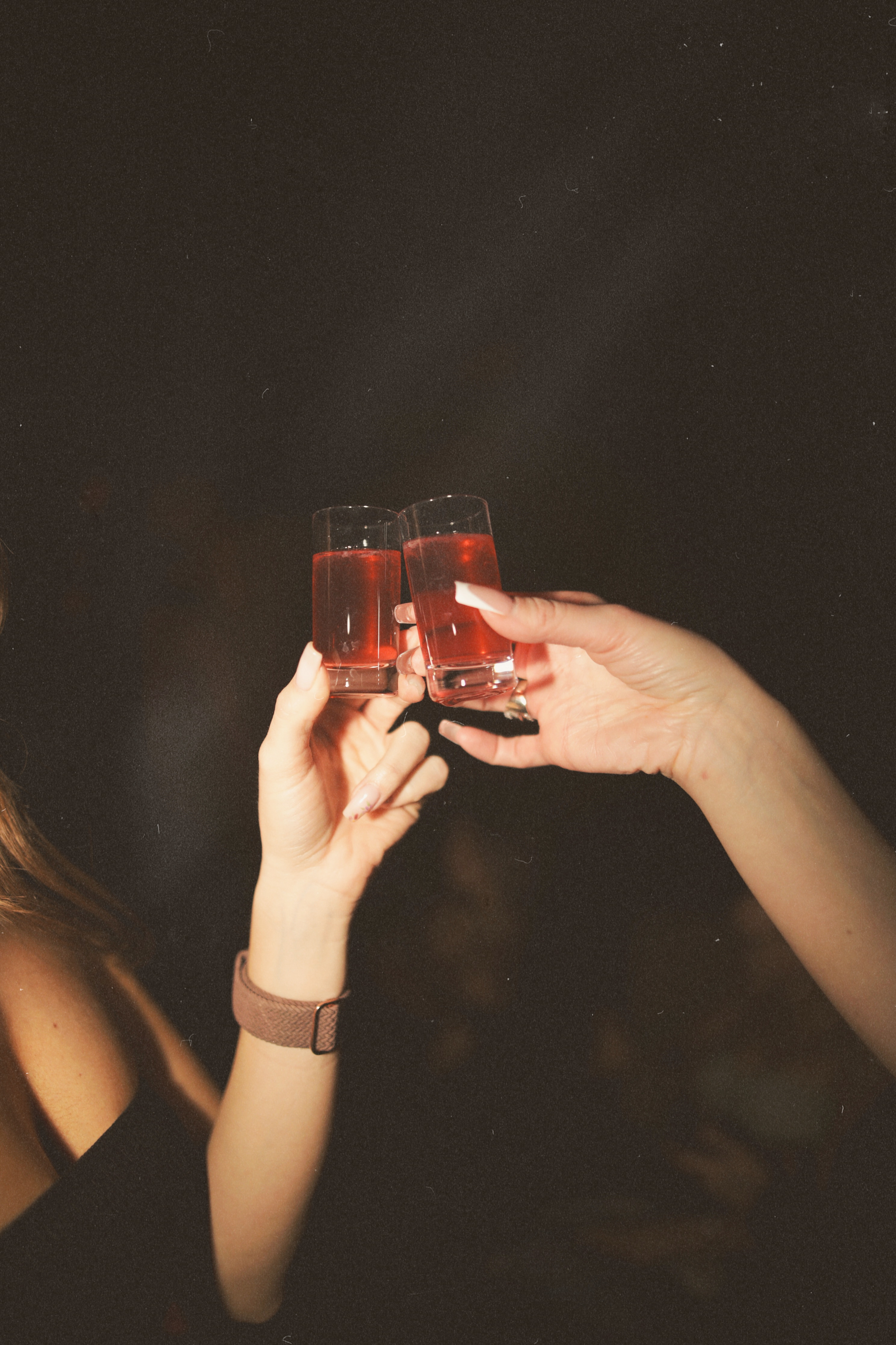 Two guests clinking red shots together at Bel-Aire Lounge in Las Vegas, celebrating nightlife and cocktails.