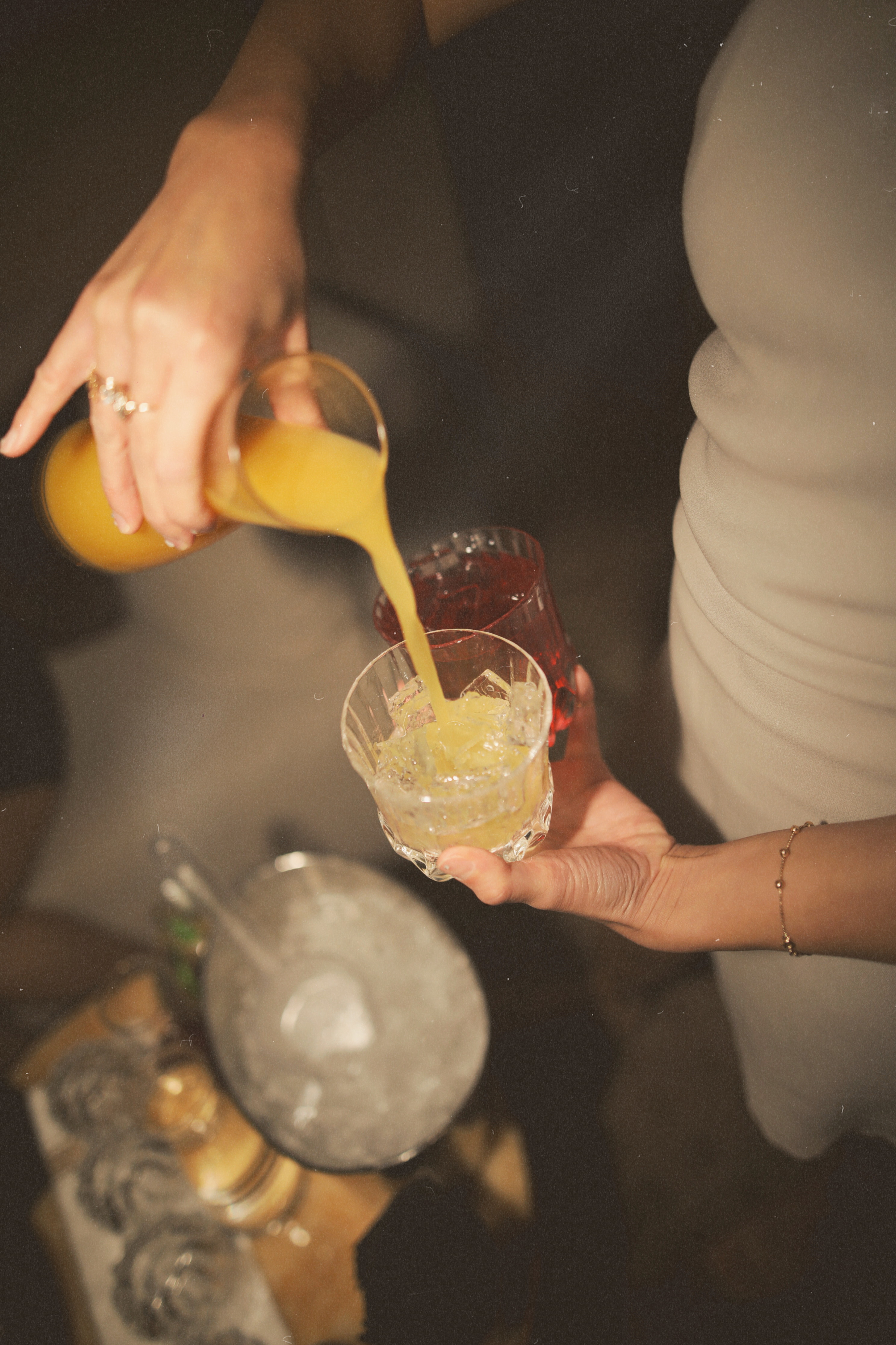 a cocktail server at the local lounge bel-aire pouring a mixed drink at a table