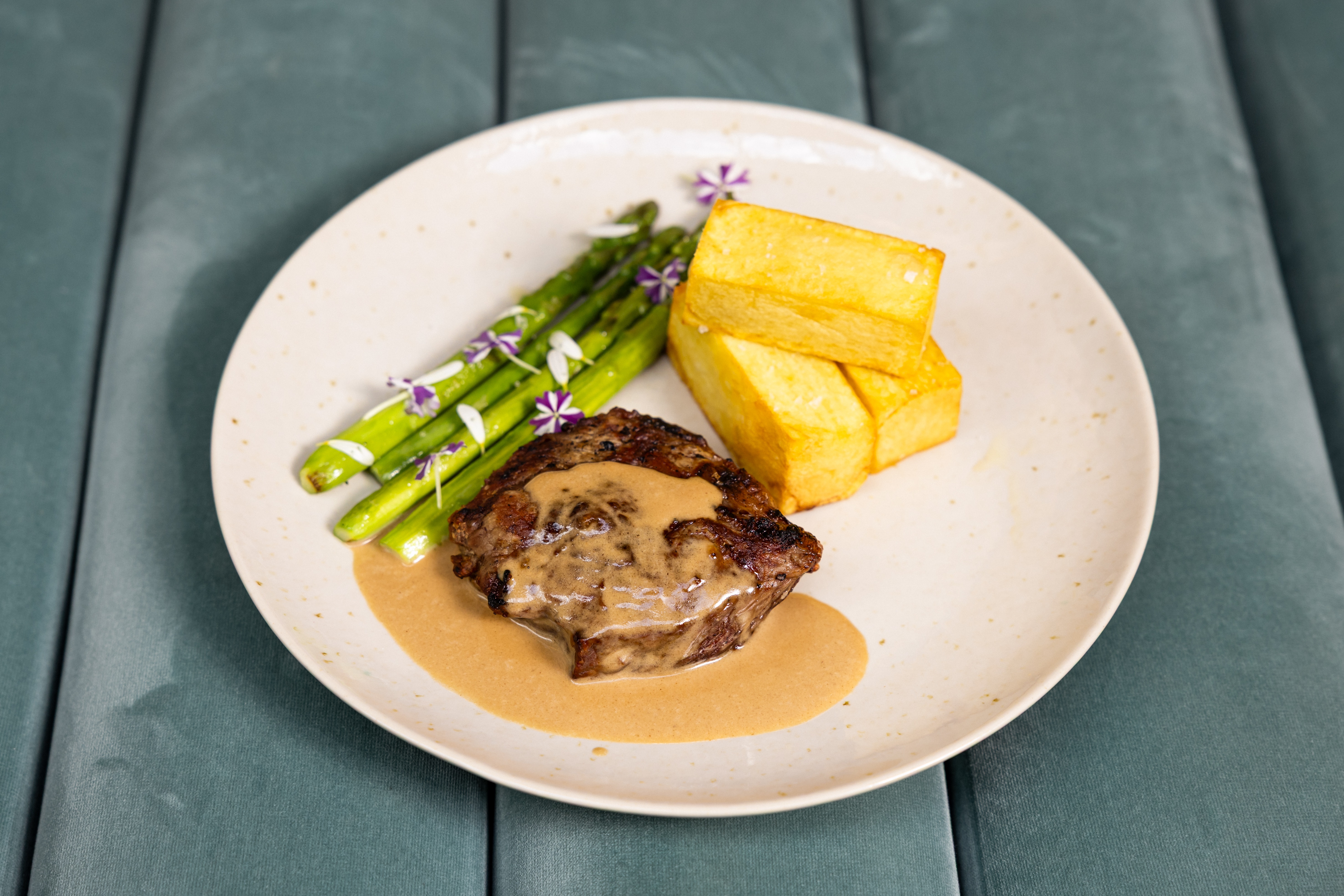 a plate of food with asparagus and steak
