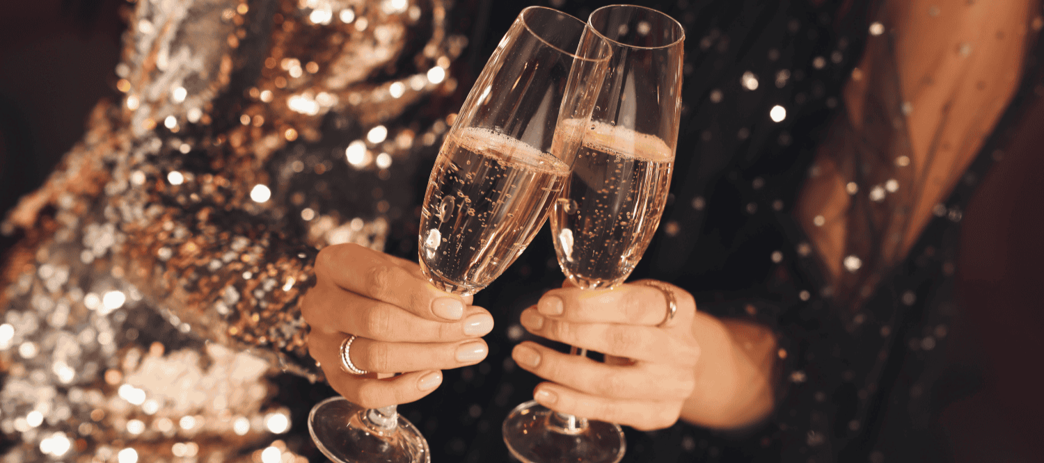 a pair of hands holding champagne glasses