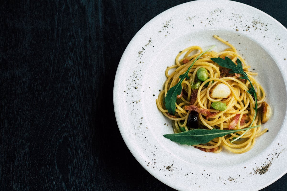 a white plate topped with pasta and vegetables