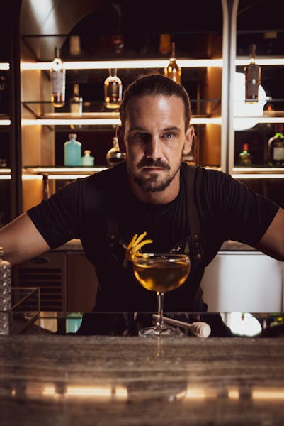 a man sitting at a table with wine glasses