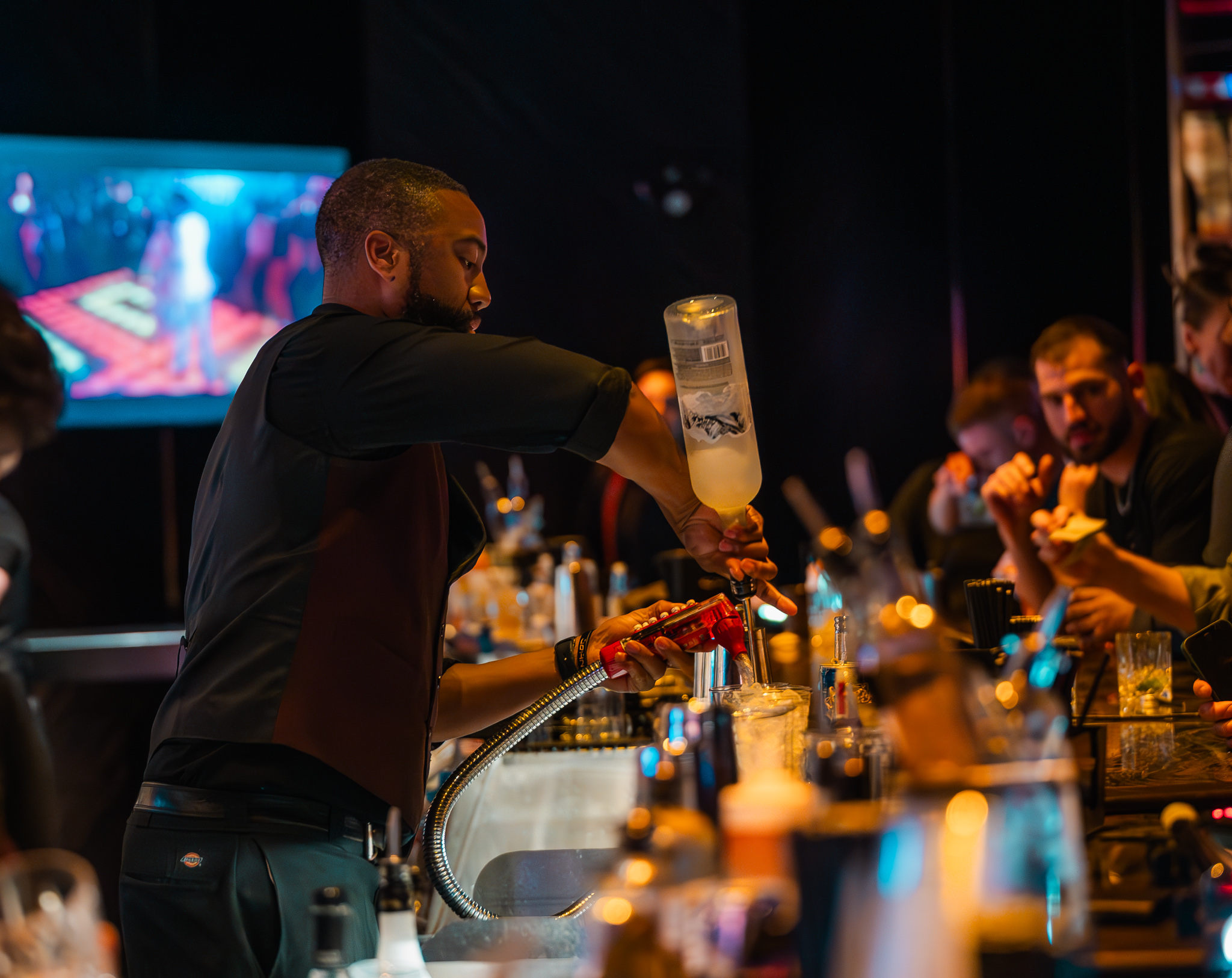 bartender making drinks for sports fans at clique