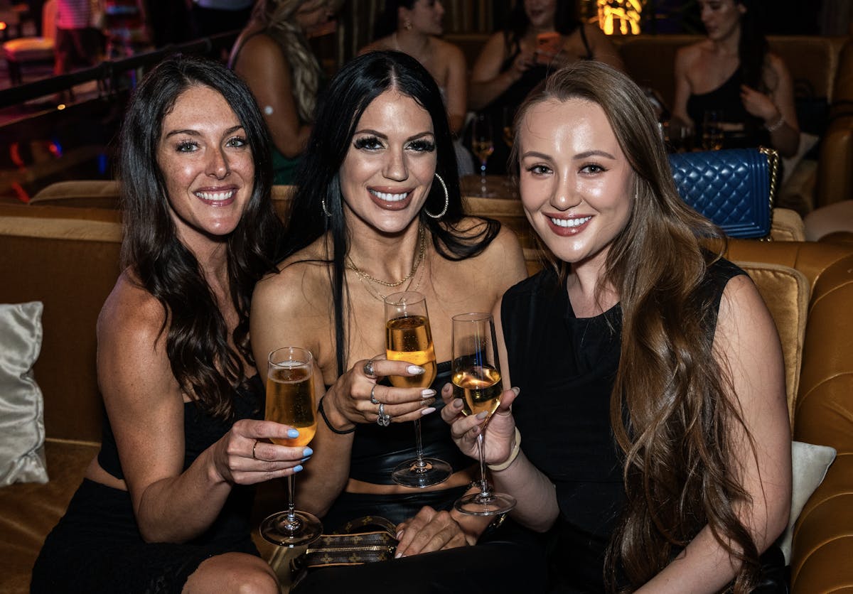 a group of people sitting at a table with wine glasses