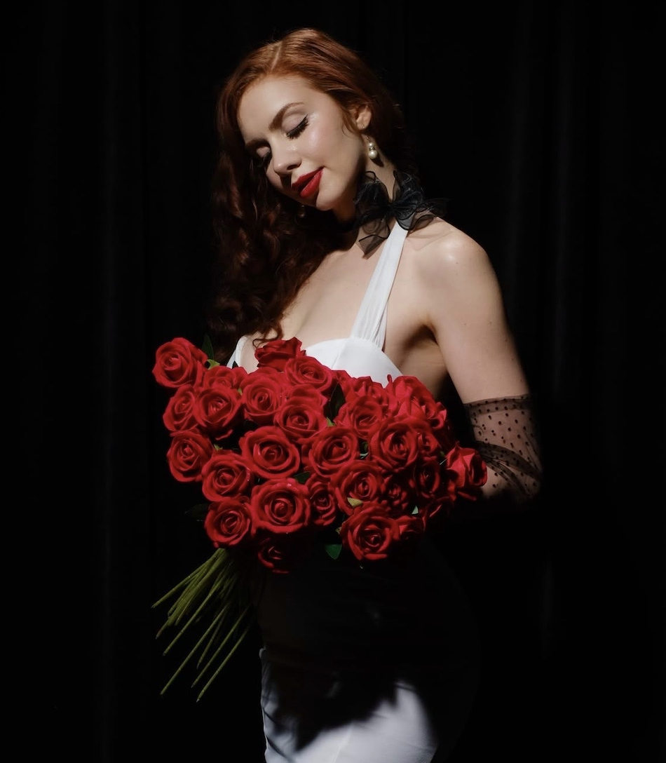 Live music artist Naomi Rose holding bouquet of roses at Clique Bar & Lounge