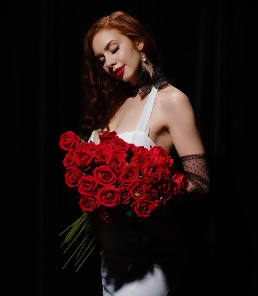 Live music artist Naomi Rose holding bouquet of roses at Clique Bar & Lounge