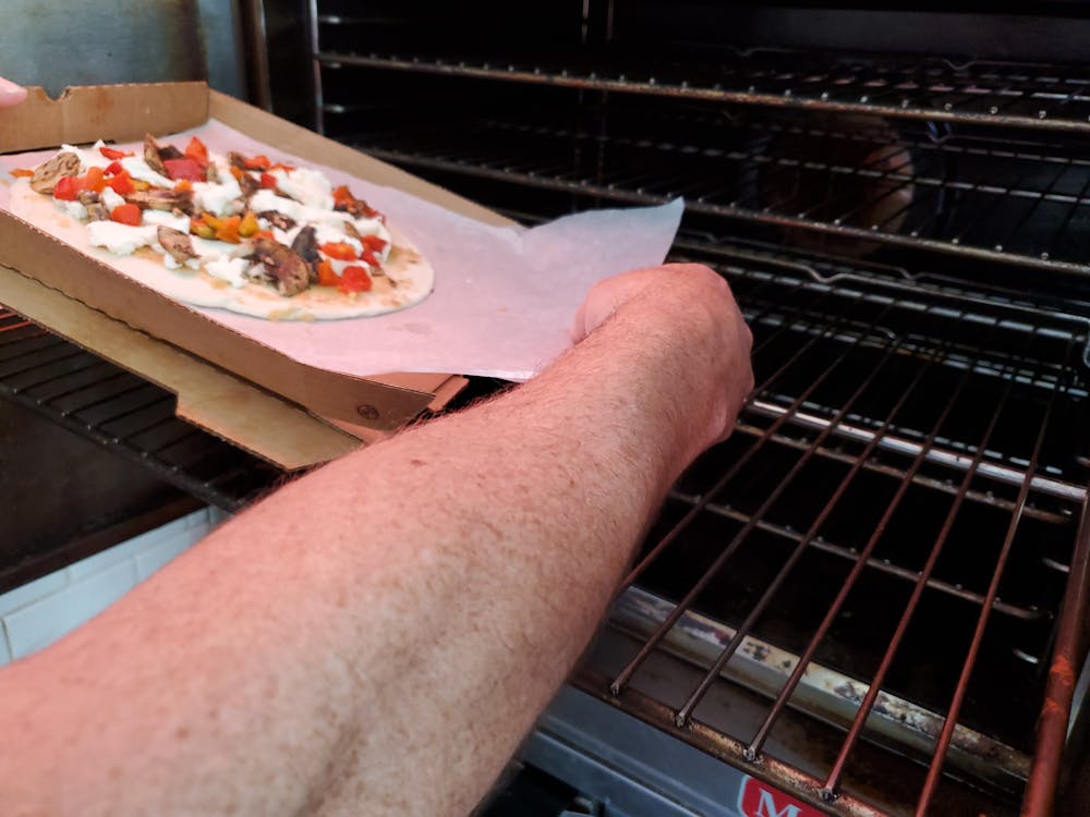 człowiek gotujący pizzę