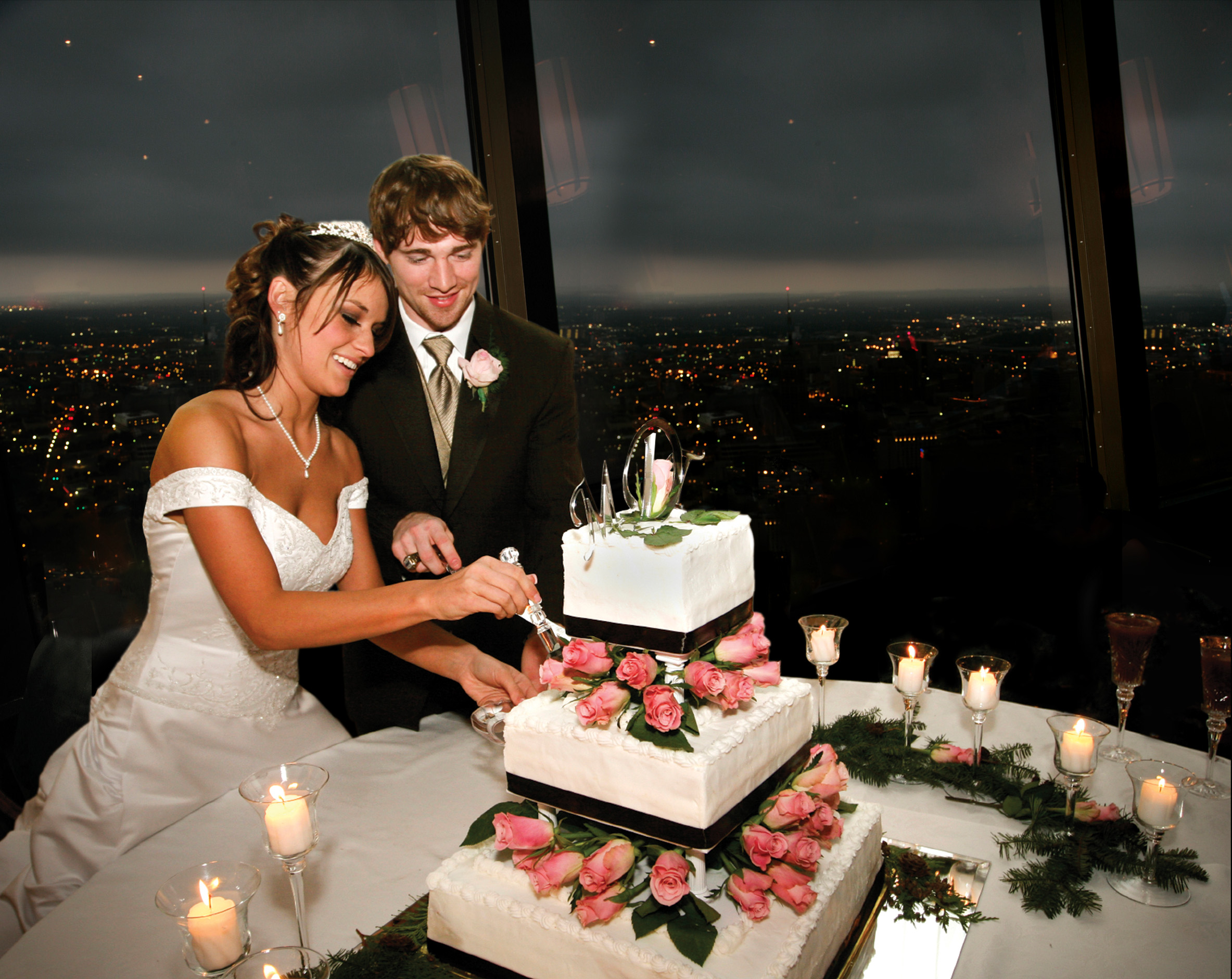 a person cutting a wedding cake