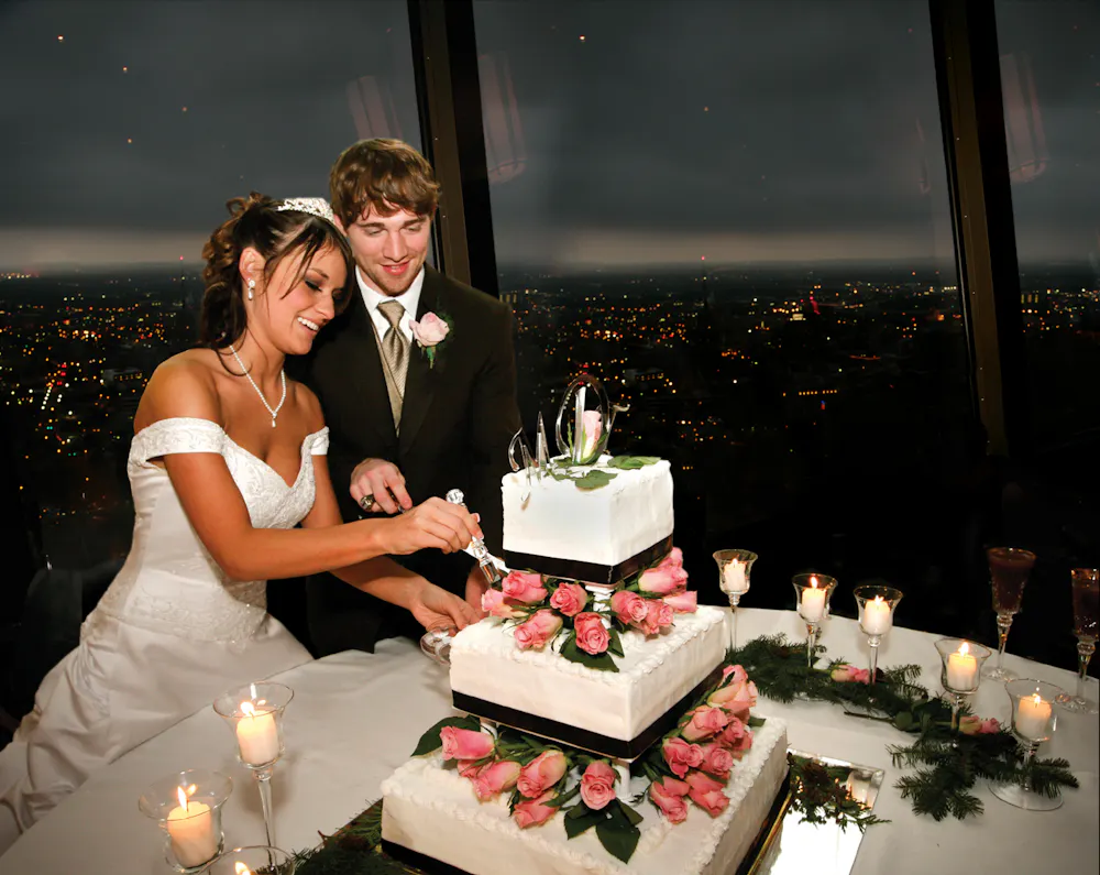 a person cutting a wedding cake