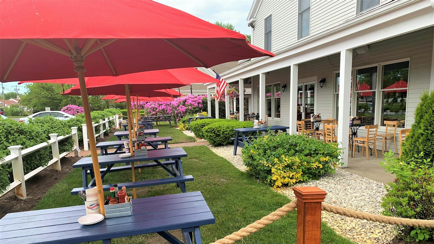 a couple of lawn chairs sitting on top of a red umbrella