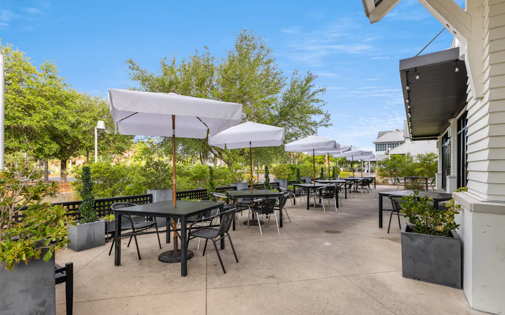 tables and chairs outside with umbrellas