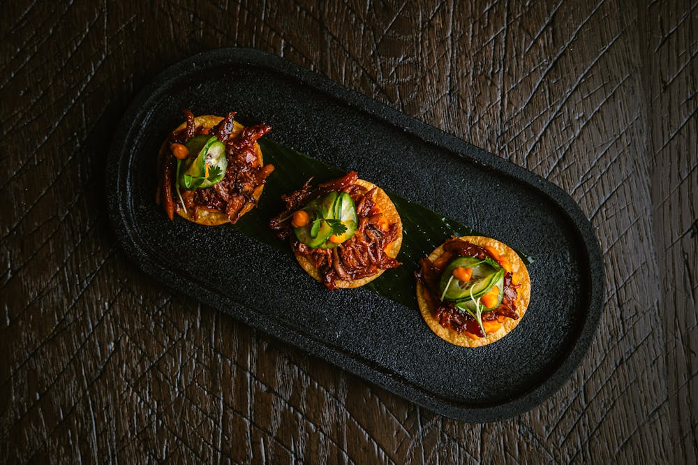 a photo of the duck confit tostadas that will be served at Amaya Modern Mexican at the cosmopolitan of las vegas