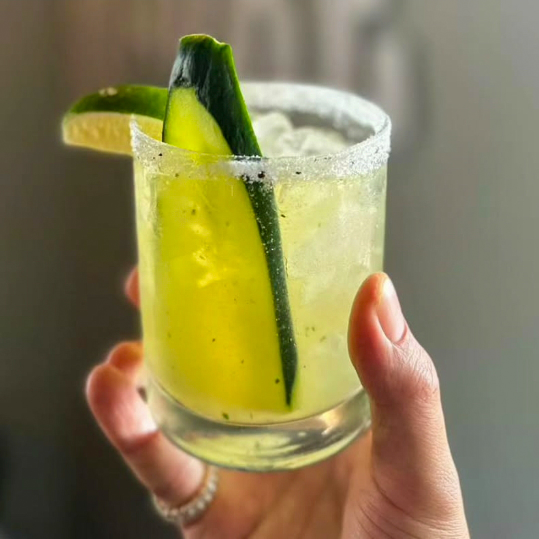 a hand holding a small glass cup