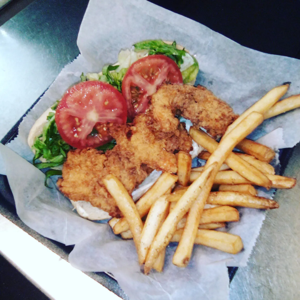a sandwich sitting on top of a pile of fries