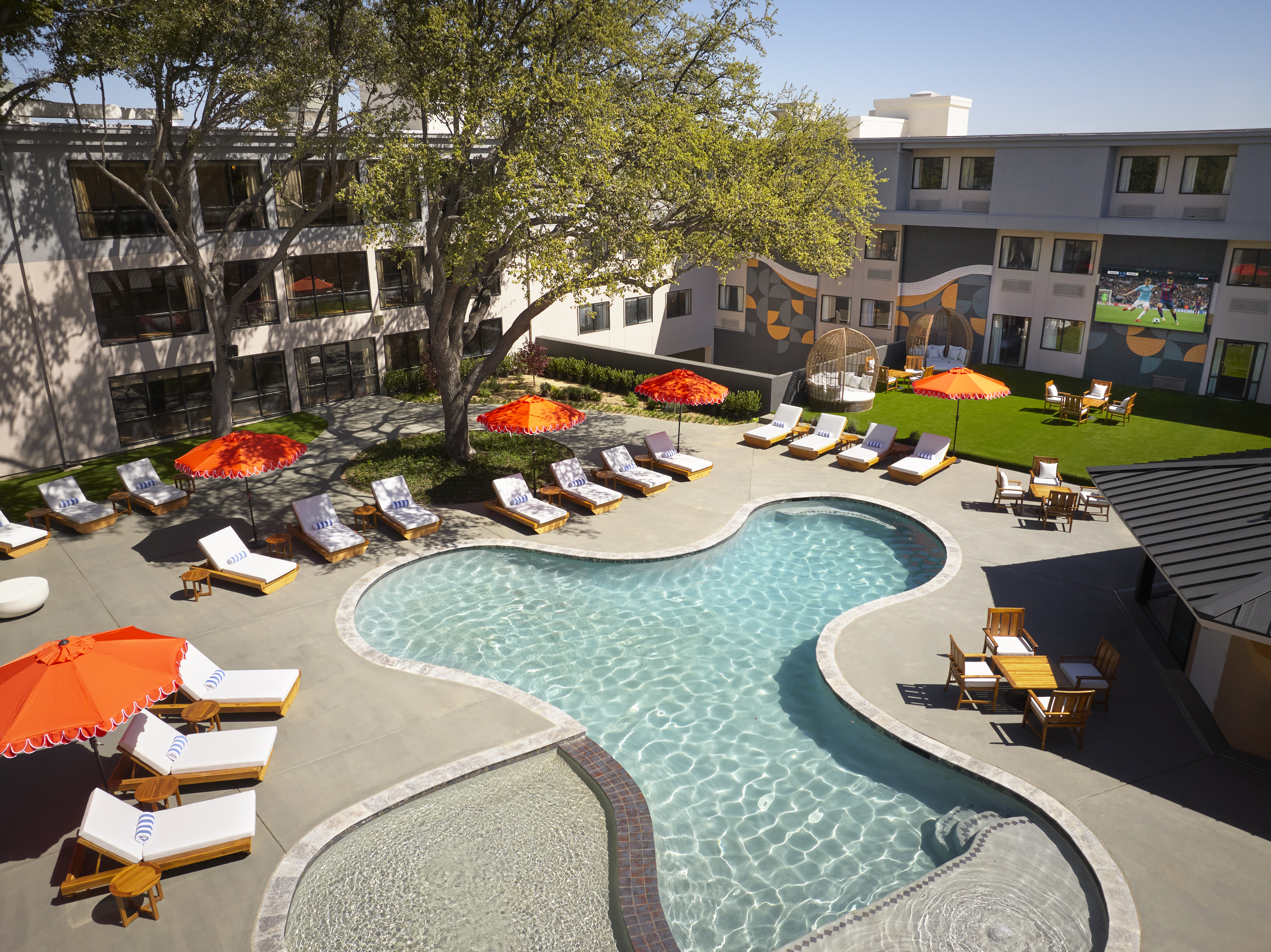 a pool with chairs and umbrellas in a hotel