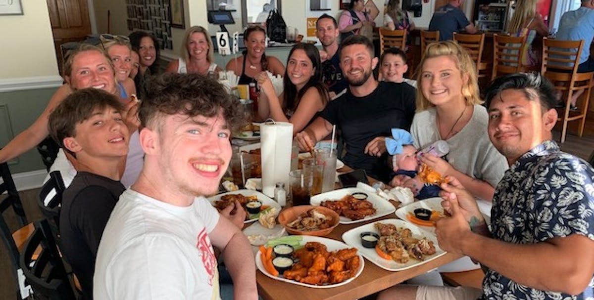 a group of people sitting at a table eating food