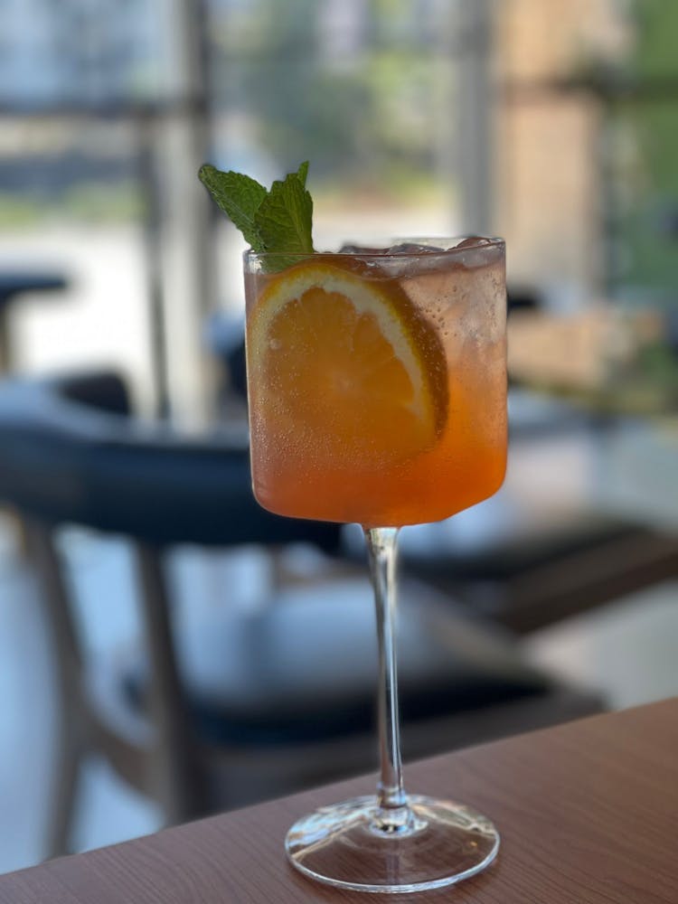 a glass of wine sitting on top of a wooden table