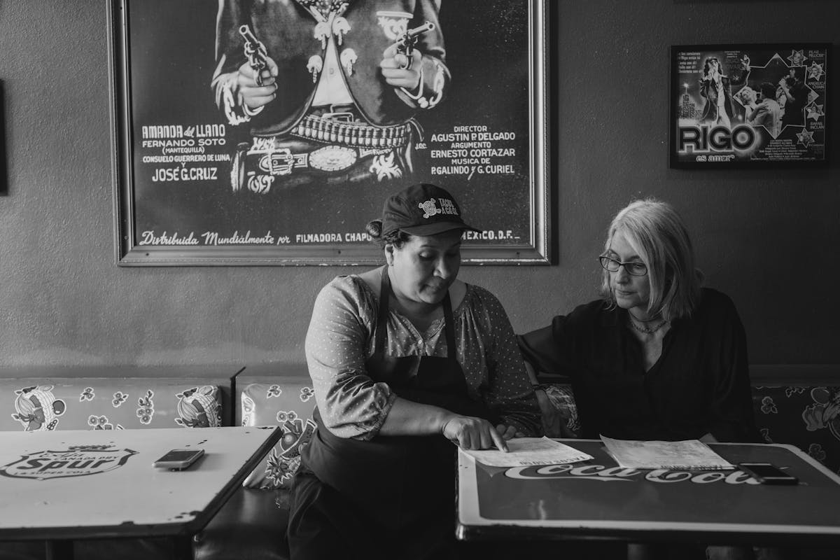 Sharon and Maribel, our founders of Tacos A Go Go, looking over a menu