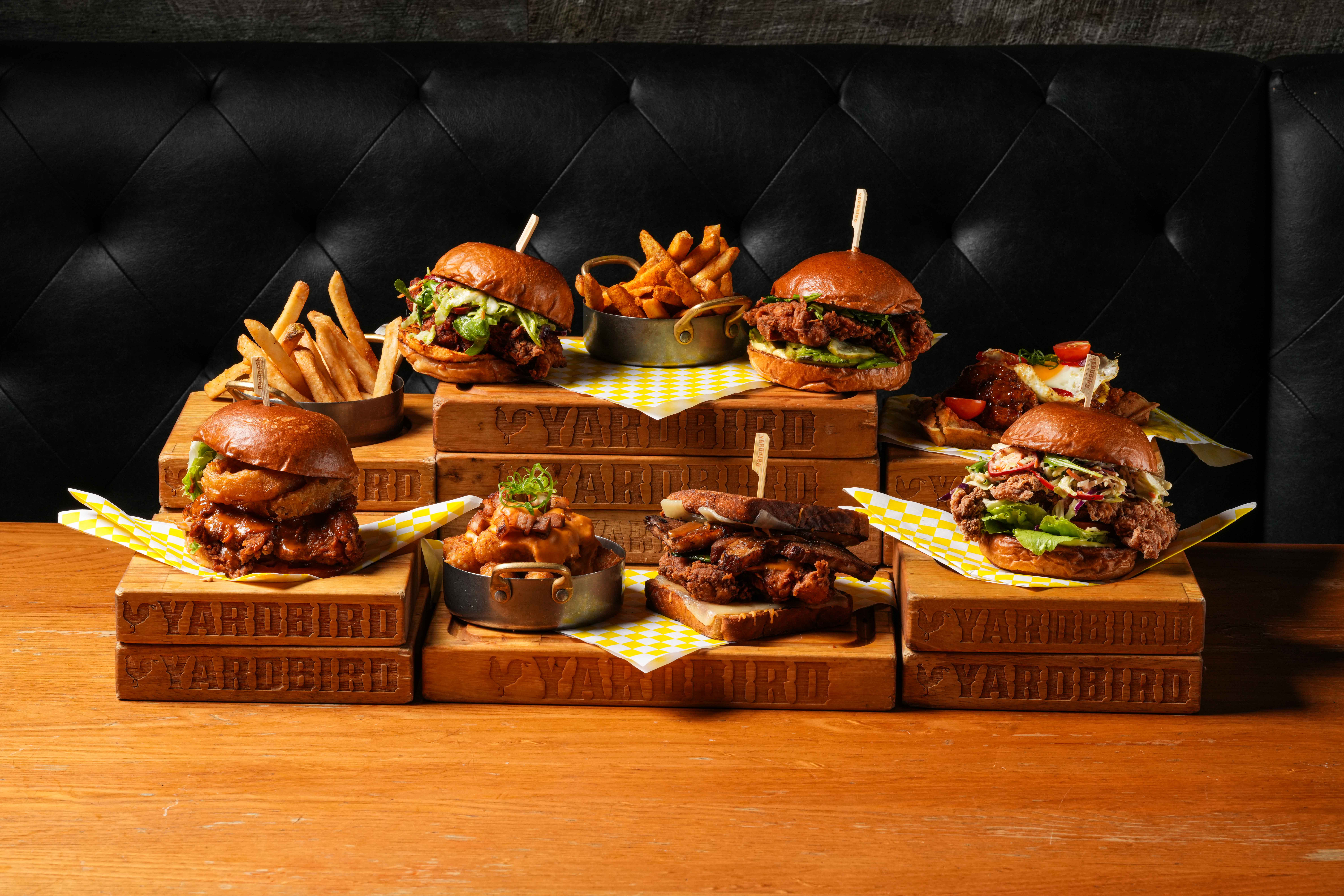 a table with burgers and fries