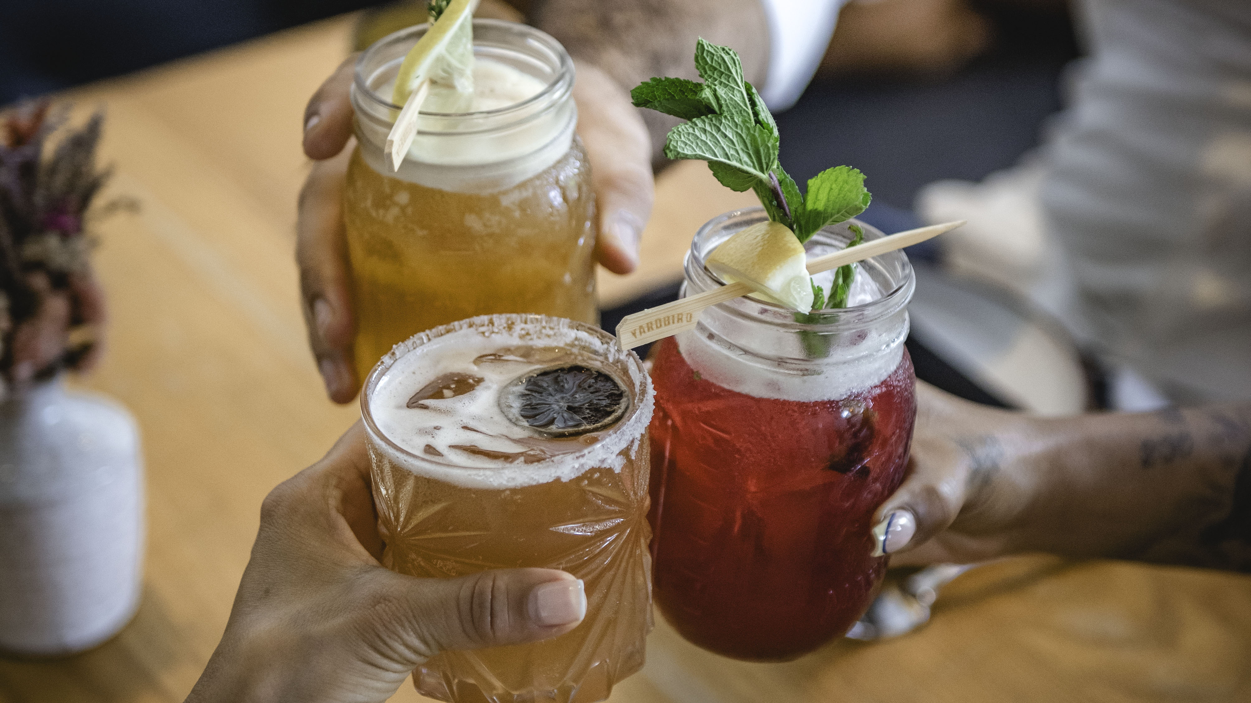 a group of hands holding drinks