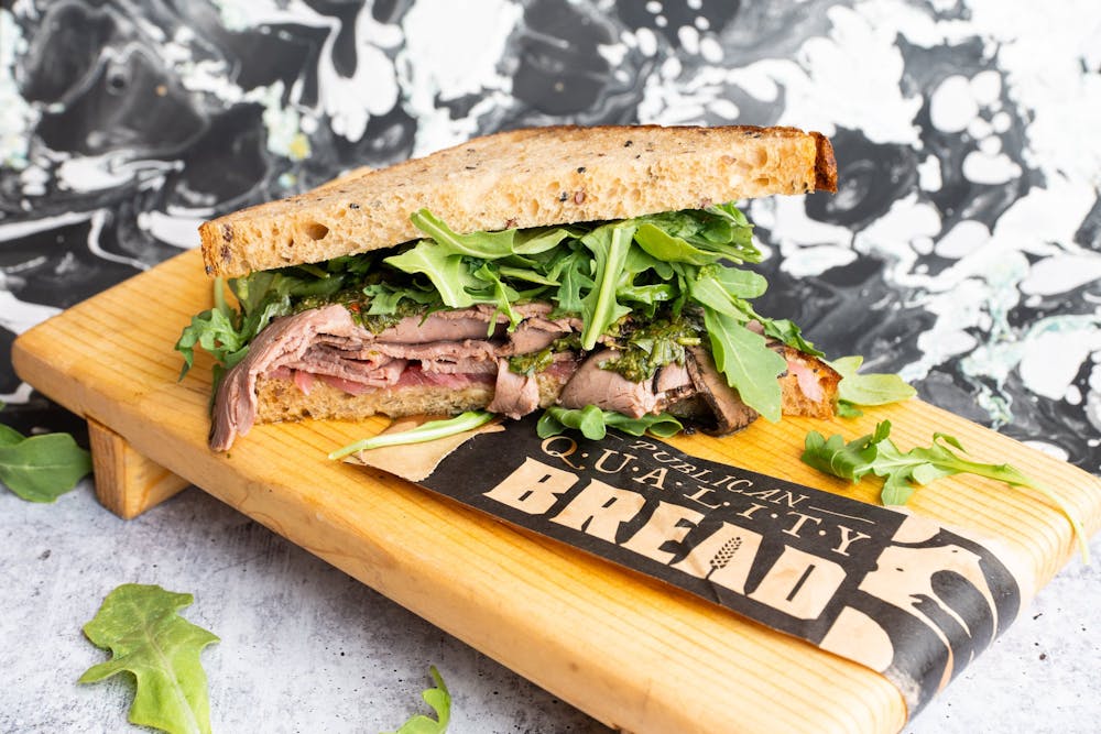 a sandwich sitting on top of a wooden cutting board