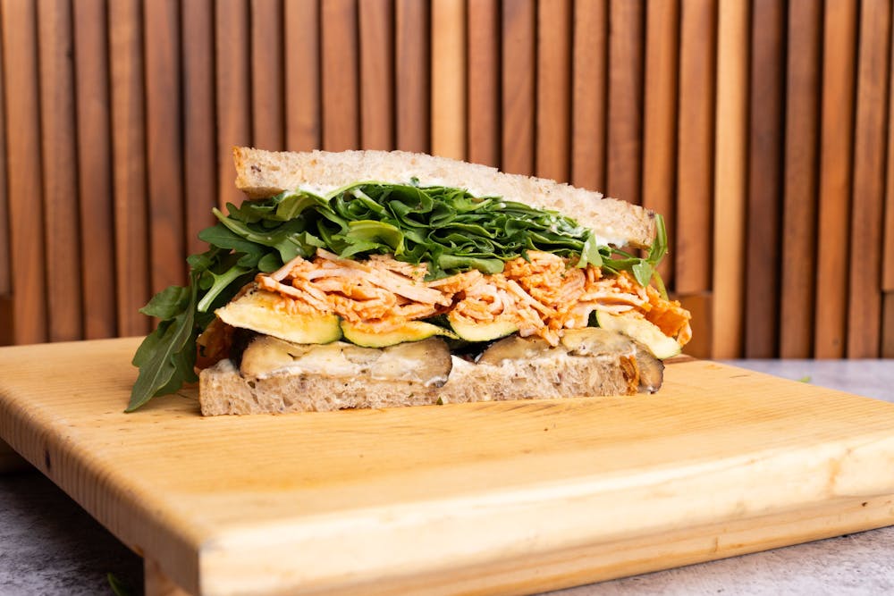 a sandwich sitting on top of a wooden cutting board